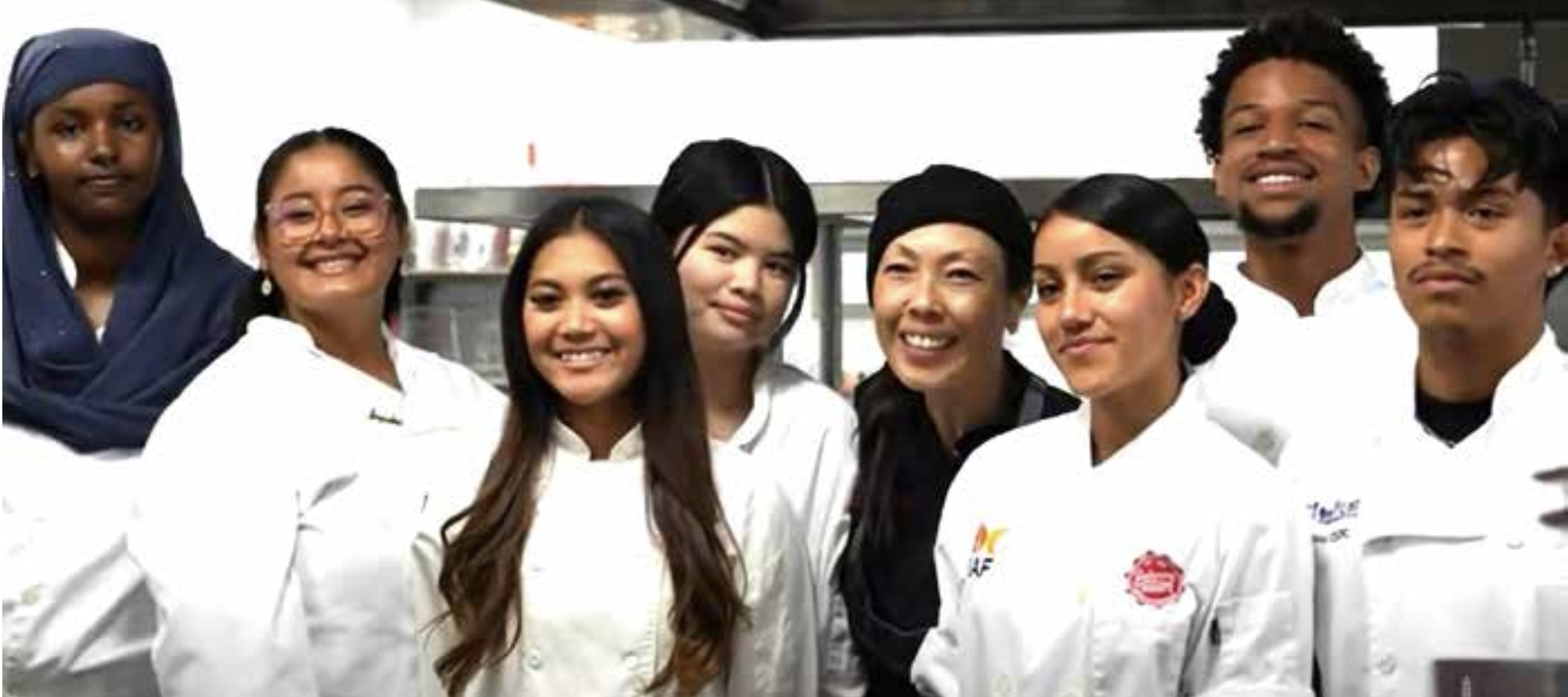 Tina Luu with students dressed in chef uniforms
